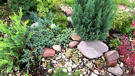 Many of the larger boulders and the exposed ledge in our landscape are incorporated into the design of the planting beds and garden paths since it is as easier to plant around the rocky obstacles than it is to move them out of the way. small rock garden - YouTube
