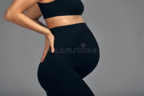 Cute Pregnant Belly Isolated On Gray Side View Of Young Pregnant Woman Embracing Her Abdomen