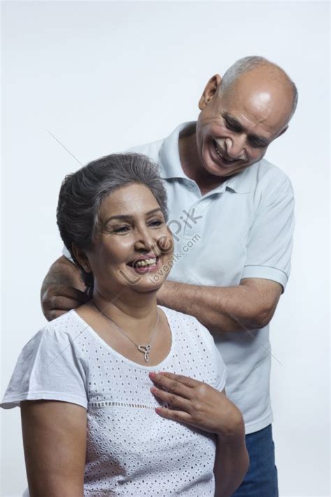 Photo Of An Old Man Tying A Necklace Around A Womans Neck Picture And