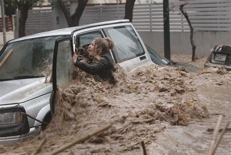 A Woman Stuck In Her Car Reacts As Flood Waters Gush Past Her During