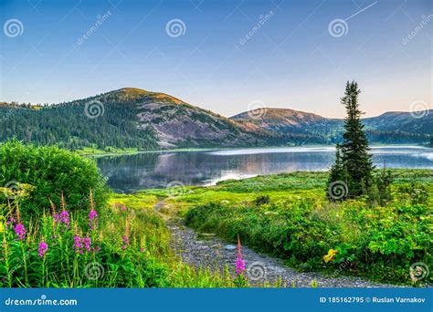 View On Mountain Lake With Hills And Green Forest During Sunrise Stock