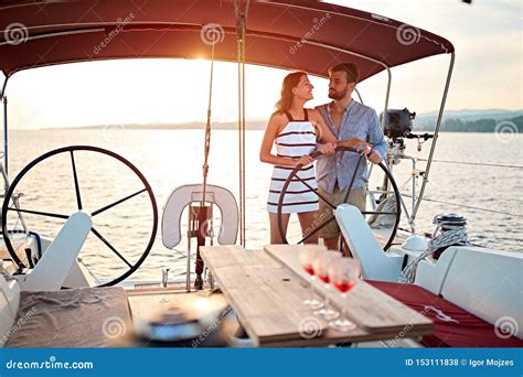 Romantic Couple Sailing On The Luxury Boat Together And Enjoy At Sunset