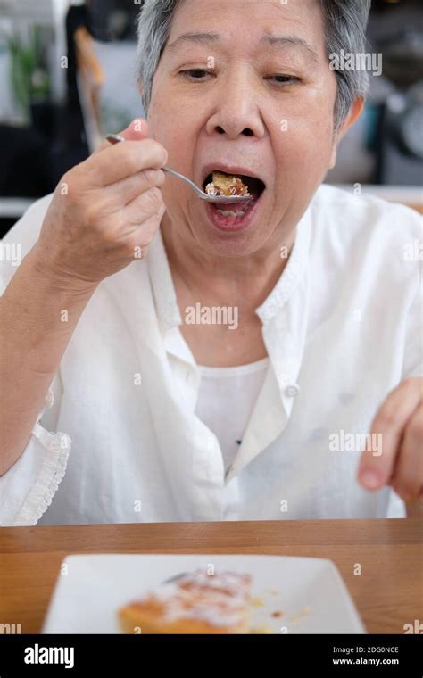 Old Asian Elderly Senior Elder Woman Eating Cake At Restaurant Mature Retirement Lifestyle