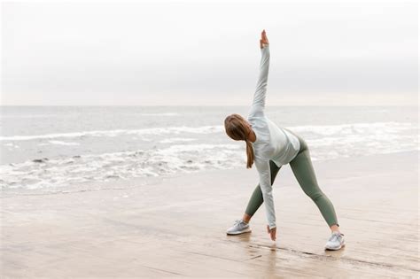 Premium Photo Full Shot Woman Stretching At Beach