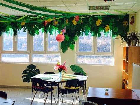 Add interest to hanging ceiling decorations in a small room by attaching multiple decorations onto one strand of ribbon, alternating large and theme ideas. Island Jungle Theme | Jungle theme classroom, Classroom ...