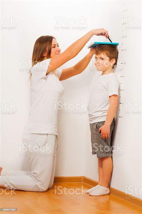 Mother Measuring Her Sons Height Against Wall Stock Photo Download