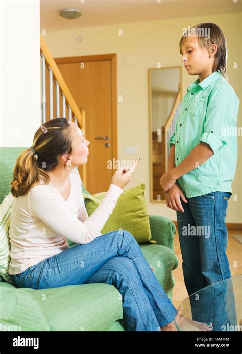 Mature Mother Scolding Teenager Son In Living Room At Home Stock Photo