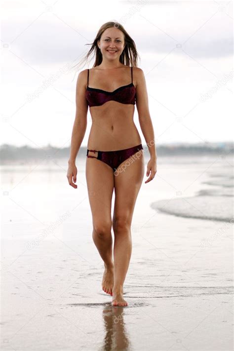 Happy Woman In Bikini Walks On A Beach Stock Photo By Arkusha