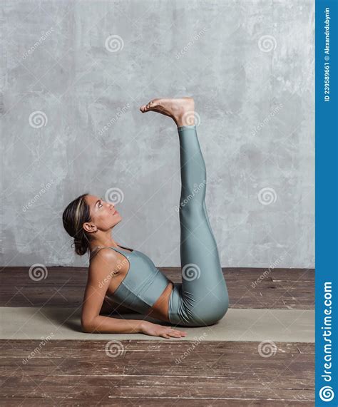 Slim Athletic Woman Practicing Yoga Lying On Mat On The Floor Doing Leg
