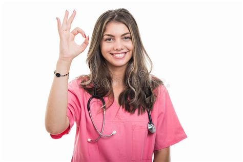 Portrait Of Beautiful Young Doctor Wearing Scrubs Showing Ok Gesture