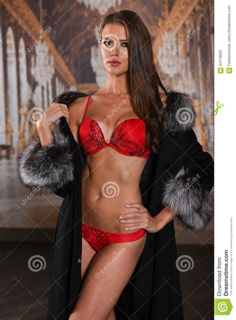 overweldigende sexy meisje status in modieuze rode lingerie en luxebontjas en het bekijken u