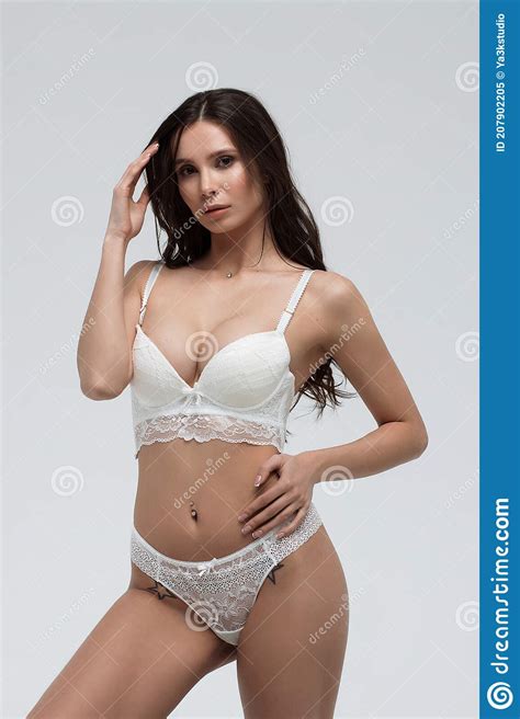 Hot Woman In White Lace Lingerie Looking At Camera Touching Body Stock