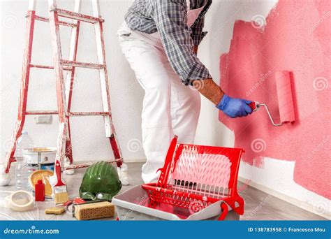 Professional House Painter At Work Painting The Wall Stock Photo