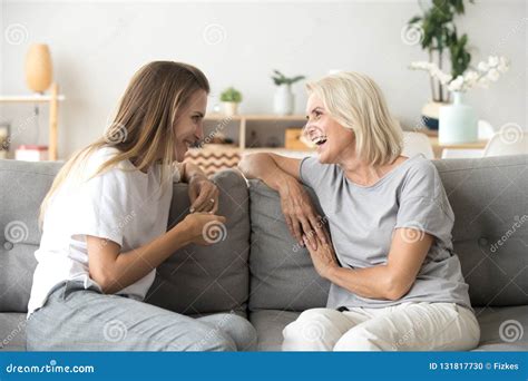 Cheerful Old Mother And Young Adult Daughter Talking Laughing To Stock