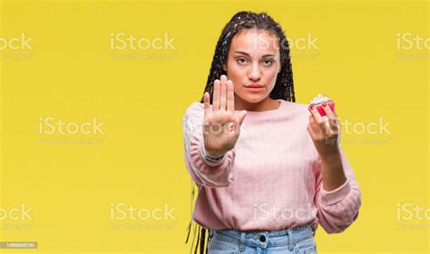 Young African American Girl Eating Cupcake Over Isolated Background