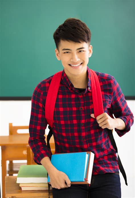 Smiling male student standing in classroom - Alta Smiles