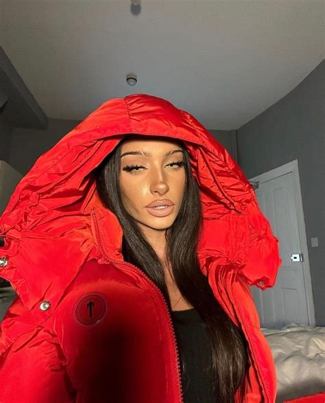 A Mannequin Wearing A Red Jacket And Black Top In A Room With A Bed