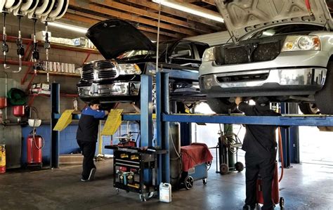Automotive Repair Two Garage Mechanics Working On Vehicles In An