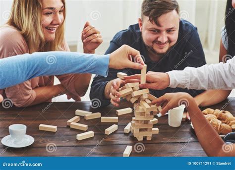 Group Of Creative Friends Sitting At Wooden Table People Having Fun