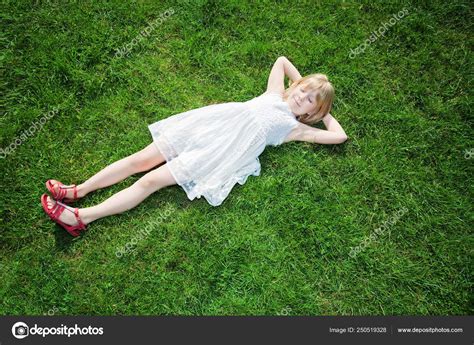 젊은 여 자가 잔디에 누워 스톡 사진 BoValentino 250519328