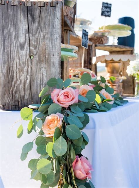 A Bouquet Of Flowers Sitting On Top Of A Table Next To An Old Wooden Fence