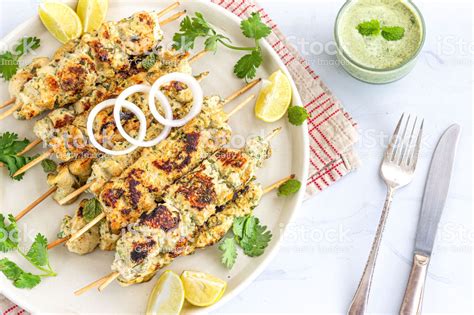 String together chicken pieces on a skewer an inch apart. Chicken Malai Tikka on Skewers in a White Plate with Green ...