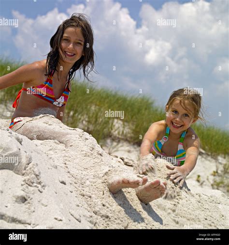 Two Girls Age Of And Playing In The Sand On The Beach Stock Photo Alamy