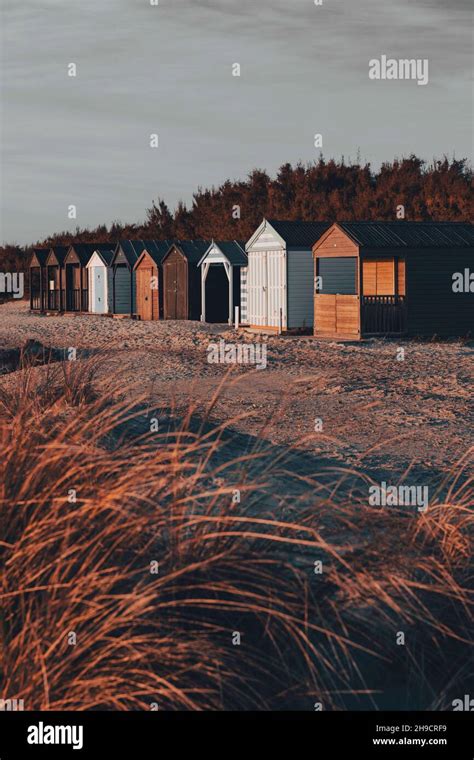 Beach Huts In A Row Beyond Sand Dunes Stock Photo Alamy