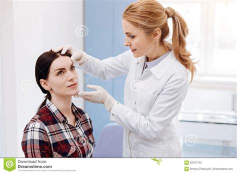 Female Plastic Surgeon Looking At Her Patients Face Stock Photo Image