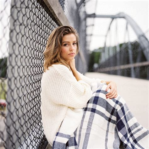 Beautiful Girl Wrapped In A Blanket Sitting On A Bridge By Stocksy Contributor Jakob