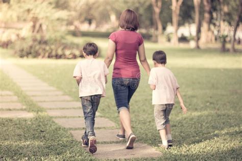 Madre Soltera Que Camina En El Parque Con Los Hijos Felices Foto De