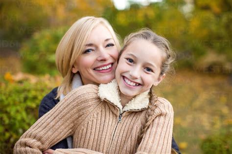 Mother And Daughter Hugging Outdoors Stock Photo