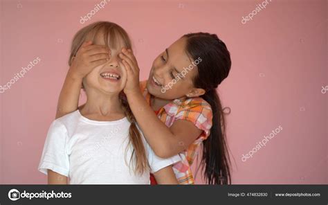 Deux filles heureuses s embrassant isolées sur fond rose image libre de