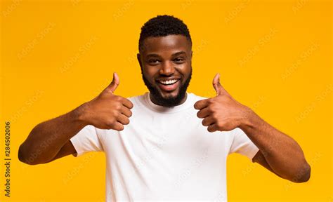 Happy African American Man Showing Thumbs Up At Studio Stock Photo