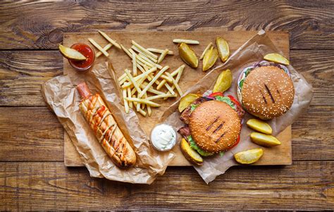 It showcases the standard of hotels and restaurants. Fast food take away top view. Hamburger, hotdog and fries ...