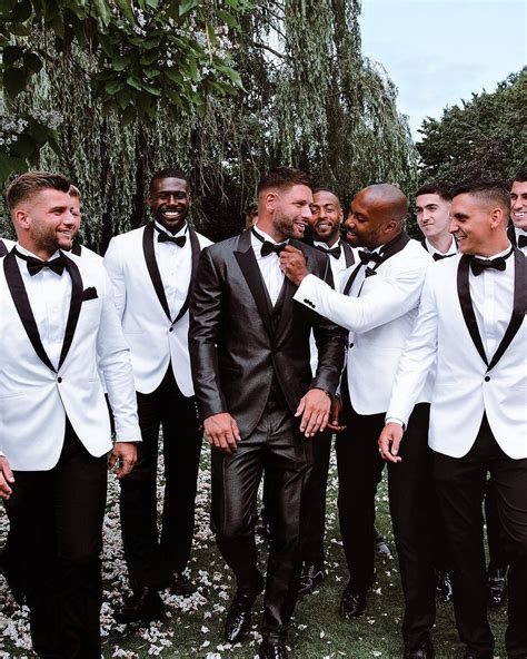 A Group Of Men In Tuxedos Standing Next To Each Other