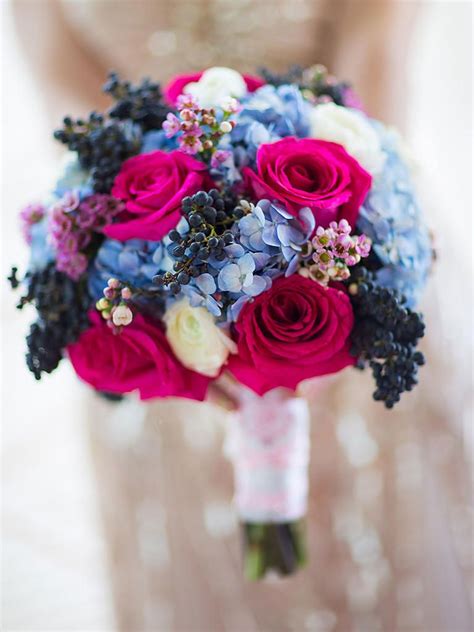 A Bridal Bouquet With Pink Roses And Blue Hydrangeas
