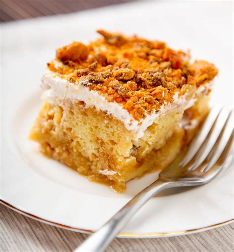 Once the cake is removed from the oven, poke holes evenly over the top of the cake using the end of a wooden spoon, a skewer or the tines of a fork. Butterfinger Poke Cake | TheBestDessertRecipes.com