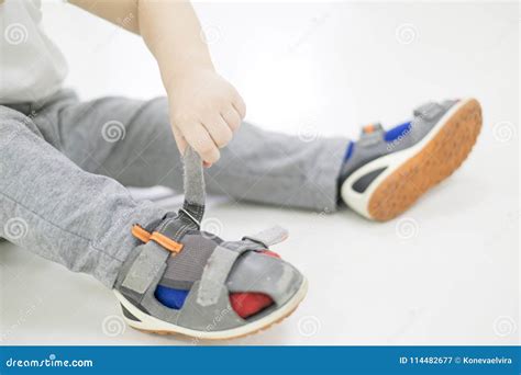 Small Child Tries To Put On His Shoes Baby Boy With Shoes In Hand How