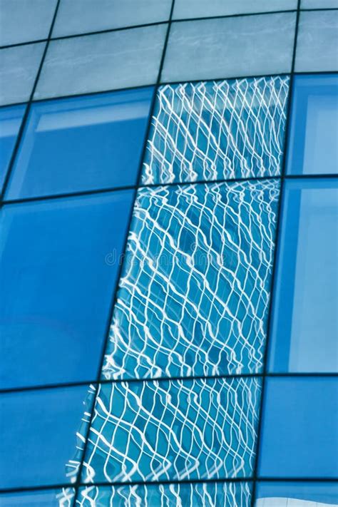 Reflection In Blue Glass Wall Of Modern Office Building Stock Photo