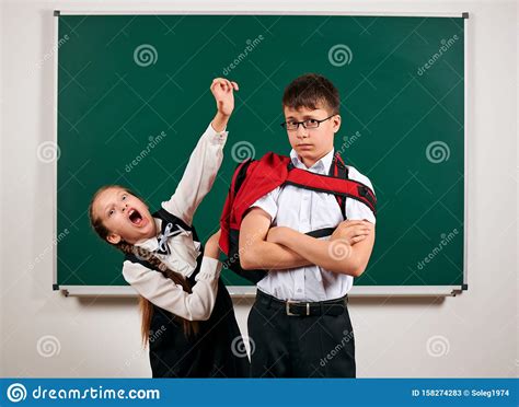 Portrait Of A Schoolboy And Schoolgirl Playing Near Blackboard