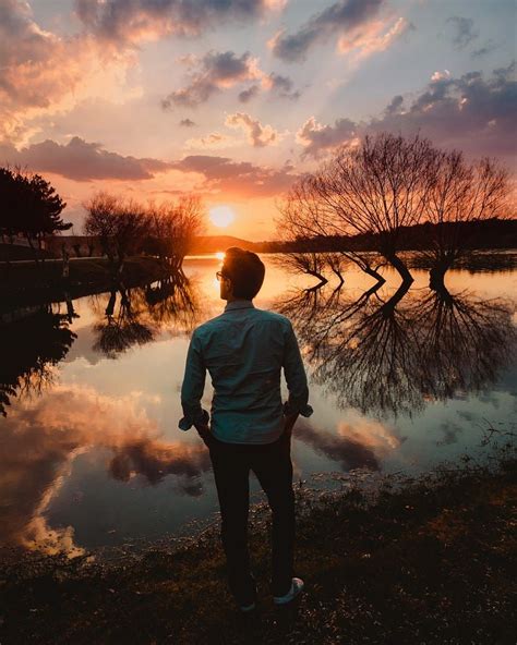 A Man Watching The Perfect Sunset By The Lake By Gokhan