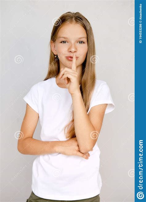 Portrait Of Teenager Girl Holding Finger Near Lips Stock Photo Image