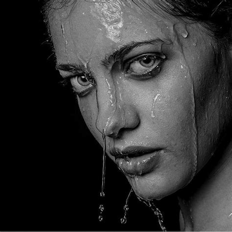 a black and white photo of a woman s face with water dripping from her mouth