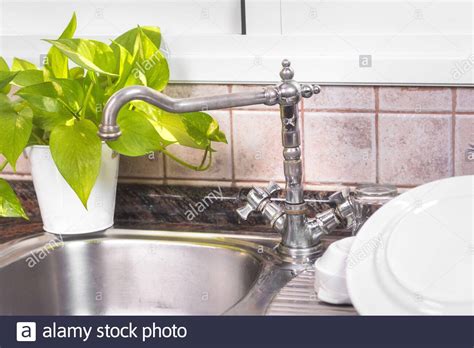 The Clean Dishes Are Drying On Rustic Kitchen Metal Sink Stock Photo