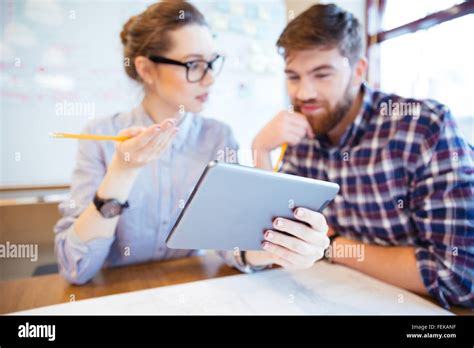 Two Business People Working With Tablet Computer In Office Focus On