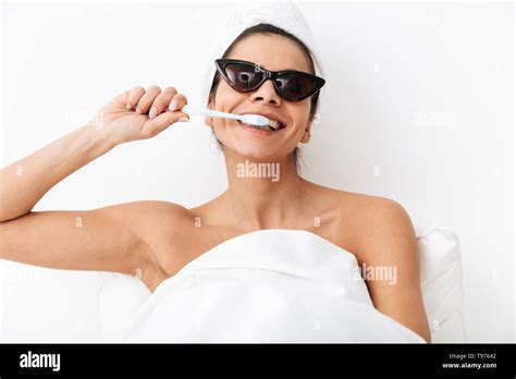 Cheerful Young Woman Sitting In Bed After Shower Wrapped In Blanket