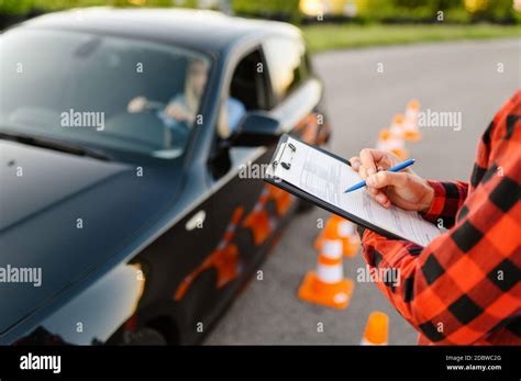 Instructor With Checklist And Woman In Car Examination Or Lesson In