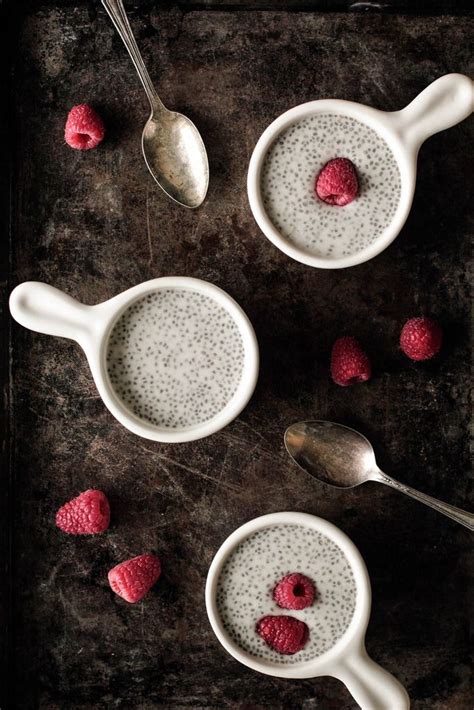 Raspberries And Chia Pudding In White Bowls With Spoons