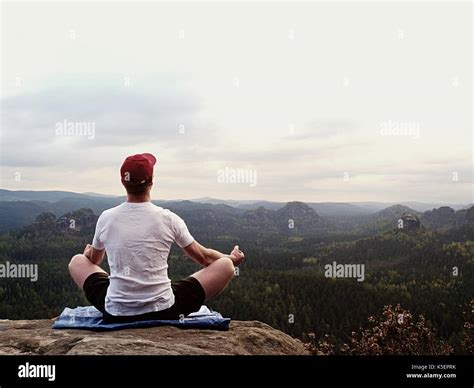 Yoga Practicing At Mountain Summit With Aerial View Of The Mountain